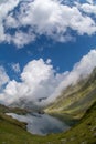 Balea lake and Balea Hotel in spring time with clouds Royalty Free Stock Photo